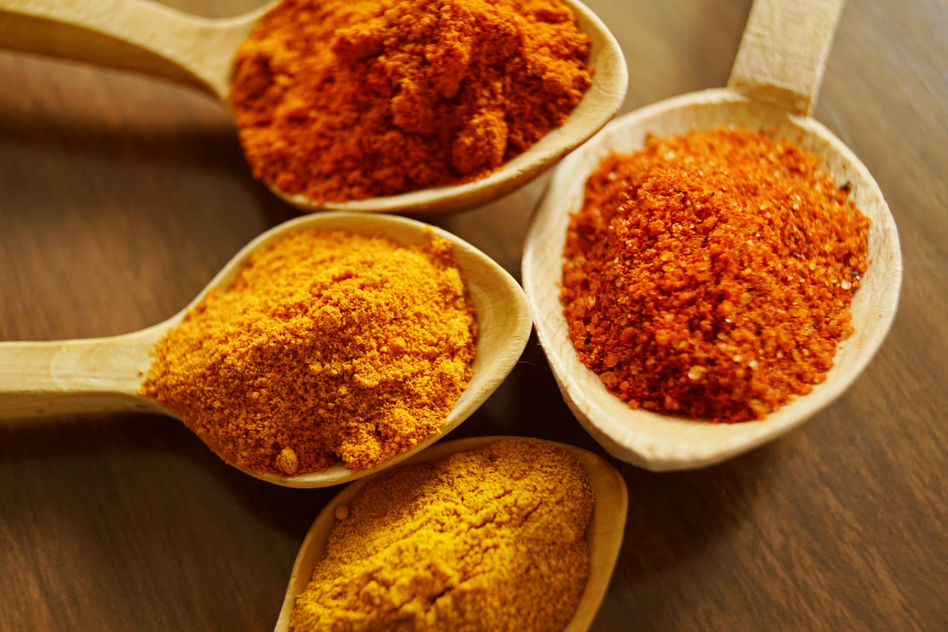 cúrcuma para dor e inflamação em pó com raízes frescas sobre mesa rústica