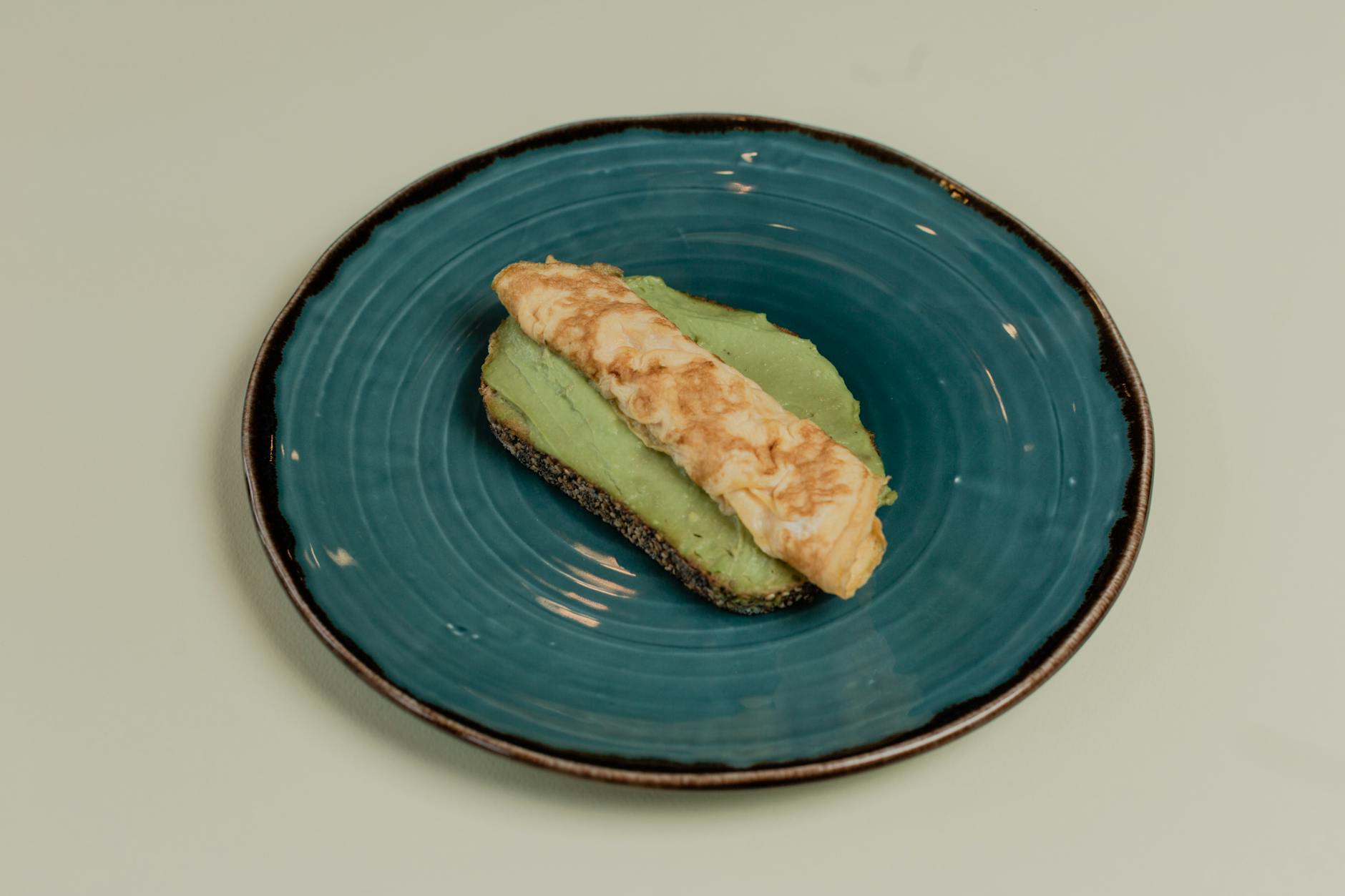 avocado toast with omelette on blue plate